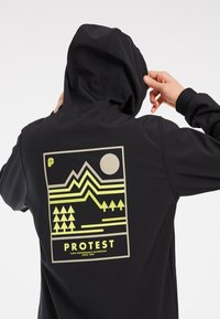 Sort hoodie med et grafisk print, der viser gule bjerge og træer sammen med en rund sol. Ribbet manchetter og hætte med snoretræk.