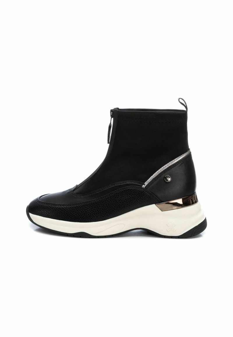 Bottines noires à la conception épurée, avec une fermeture éclair et des panneaux texturés ornés d'accents métalliques, reposant sur une semelle de style sneaker blanche.