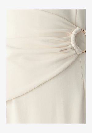 Balta auduma ar smalku diagonālu ribošanu, kas izceļas ar krokām viduklī, nostiprinātām ar zelta krāsas aploksni.