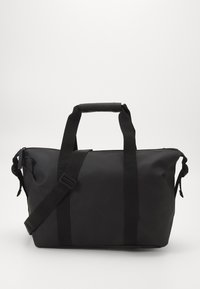 Sac de sport étanche noir avec une poignée robuste, une sangle d'épaule ajustable et un fond plat. Présente un design minimaliste et un logo embossé.