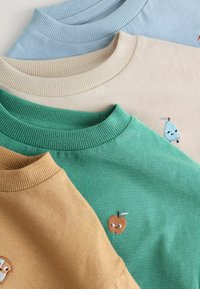 Quatre sweatshirts à col rond pliés en bleu clair, beige, vert et moutarde, chacun avec de petits personnages de fruits brodés près de l'encolure.