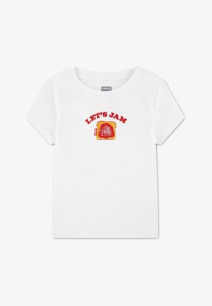 T-shirt en coton blanc avec texte brodé rouge "LET'S JAM" au-dessus d'une image d'une tranche de pain avec de la confiture. Manches courtes et col rond.