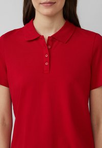 Rode polo-shirt van gladde katoen, voorzien van een klassieke kraag en een drieknops-sluiting, met korte mouwen en zonder zichtbare patronen.