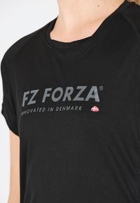 Svart kortärmad t-shirt med "FZ FORZA" i fet grå text och "INNOVATED IN DENMARK," prydd med en liten röd dansk flagga.