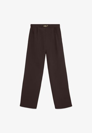 Plašas bikses tumši brūnā audumā ar gludu tekstūru, ar zelta toņa aizdari pie jostas un priekšpusē krokām.