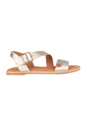 Sandalias planas metálicas doradas con dos cintas anchas y una hebilla lateral. Material texturizado y una plantilla marrón claro con un borde parecido al yute.