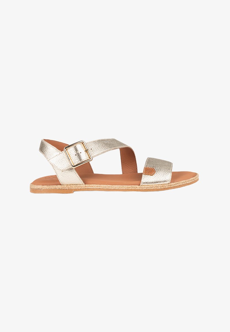 Sandalias planas metálicas doradas con dos cintas anchas y una hebilla lateral. Material texturizado y una plantilla marrón claro con un borde parecido al yute.