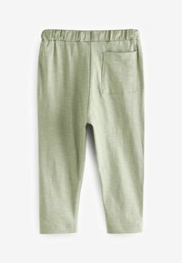Pantalons en coton stretch vert avec une taille élastique et une poche arrière unique. Texture lisse avec un motif tissé subtil.