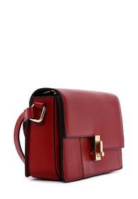 Borsa a tracolla in pelle rossa con forma rettangolare, hardware dorato e chiusura a pattina. Presenta una tracolla sottile e bordi neri a contrasto.