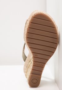 Semelle d'une sandale compensée avec fond en caoutchouc montrant des rainures horizontales, taille 4½, nom de la marque "Gabor", et plateforme en jute tressé.