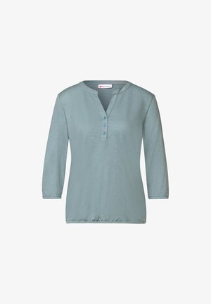 Světle modrý dlouhý rukáv s výstřihem do V a třemi knoflíky. Měkká textura, elastické manžety a nařasený lem. Hladká, lehká tkanina.