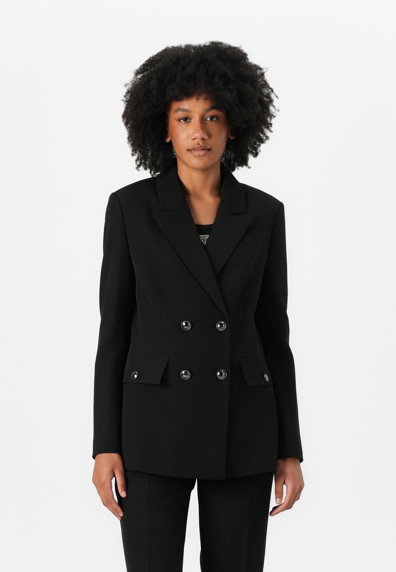 Blazer nero doppiopetto con rever a punta, tasche frontali e bottoni lucidi. Vestibilità tailored con texture morbida, adatto per abbigliamento formale.