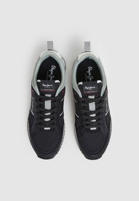 Paire de baskets Pepe Jeans noires et grises avec lacets, détails en mesh et semelles intérieures siglées, vues de dessus sur fond gris.