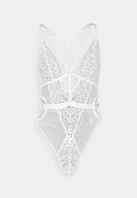 Body in pizzo bianco con design incrociato, caratterizzato da complessi motivi floreali e dettagli in rete. Spalline regolabili e gambe alte.