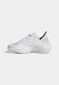 White athletic shoes with a textured knit upper, prominent rounded sole, and a black accent on the heel. Lightweight and streamlined design.