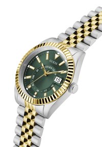 Montre en acier inoxydable argent et or avec un cadran vert, des index horaires blancs, un affichage de la date et un design de lunette cannelée.