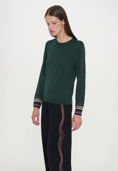 Pulover verde tricotat cu mâneci lungi, având manșete stripe în nuanțe de albastru, roșu și alb. Guler simplu, rotunjit.