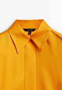 Chemise jaune vif à col avec patte de boutonnage dissimulée, confectionnée en tissu lisse, taille petite d'après l'étiquette, de la marque Massimo Dutti.