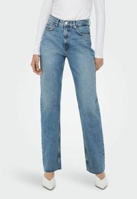 Hemdblauwe, high-waisted jeans met een rechte pijp, voorzien van contrasterende stiksels en een vijf-vakken ontwerp, gecombineerd met witte schoenen.