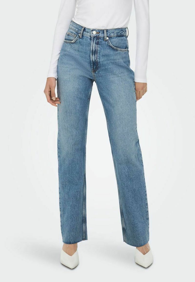 Hemdblauwe, high-waisted jeans met een rechte pijp, voorzien van contrasterende stiksels en een vijf-vakken ontwerp, gecombineerd met witte schoenen.