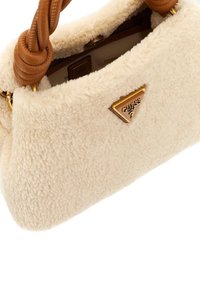Borsa a tracolla in pelliccia sintetica beige con logo triangolare dorato, manico intrecciato marrone e chiusura con zip. Texture morbida e forma strutturata.