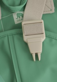Groen waterdicht materiaal met een beige gesp en band, voorzien van een klein olifantenlogo en zichtbare stiksel details.