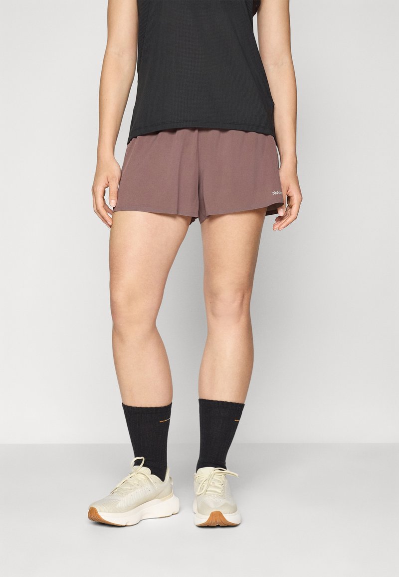 Brown athletic shorts with a loose fit, paired with black socks and beige sneakers. Thin, lightweight fabric, suitable for sports or casual wear.