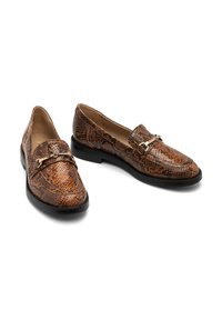 Ruskean keinonahkaisia käärmeennahkakuosisia loafer-tossuja, joissa on litteä musta pohja, koristeellinen kulta ketju etuosassa ja sileä sisävuori.