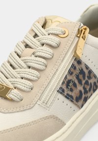 Baskets en cuir beige avec des accents en daim texturé et un panneau à imprimé léopard. Dotées de pièces métalliques dorées et d'une fermeture éclair. Lacets ronds.