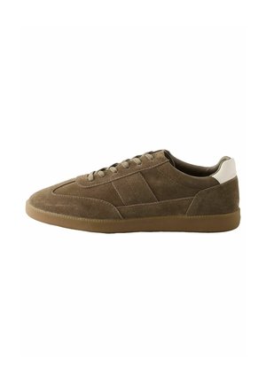 Bruine suede sneaker met een lage profiel, ronde neus en subtiele zijstrepen. Voorzien van veters en een crèmekleurige hielaccent.