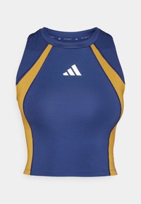 Top sportivo corto blu navy e oro con scollatura rotonda, caratterizzato da pannelli laterali a contrasto e un logo bianco sul petto.
