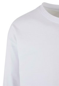White long-sleeved t-shirt made from cotton, featuring a round neckline and smooth texture without patterns or embellishments.