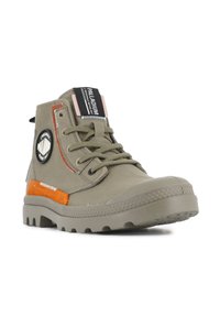 Botines de tobillo verde oliva con suela de goma, que cuentan con un parche de logo negro, acentos naranjas y detalles de tejido texturizado.