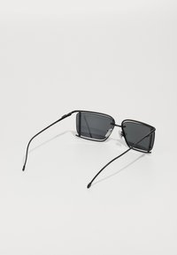 Black rectangular sunglasses with dark lenses, slim metal frame, and curved black arms. Light silver accents at the bridge and hinges.