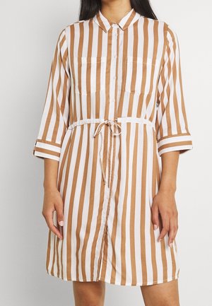 Robe rayée marron et blanche avec un devant à boutons, un col et des manches retroussées ; possède deux poches poitrine et une ceinture assortie.