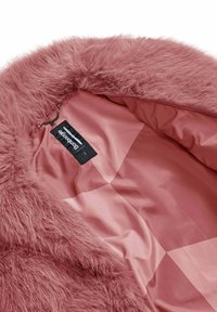 Interno di una giacca in pelliccia sintetica rosa con una fodera rosa liscia e satinata. Presenta un'etichetta con "bomboogie" e un dettaglio con gancio a catena.