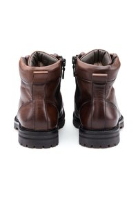 Bottines en cuir marron avec fermetures éclairs, col rembourré, panneaux latéraux texturés et semelles en caoutchouc robustes présentant des rainures horizontales.
