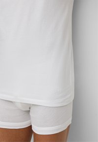 T-shirt en coton blanc avec une coupe droite et un logo "BOSS" brodé à l'ourlet, associé à des boxers en coton blanc.