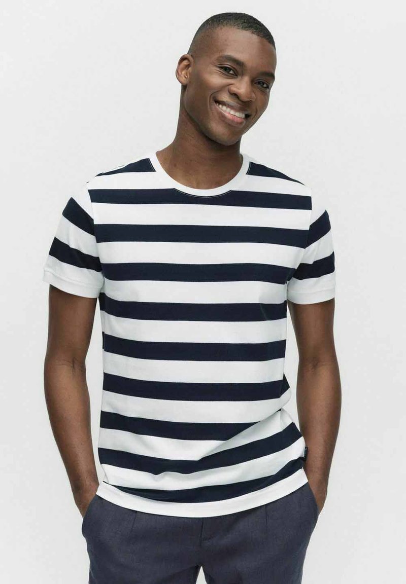 Marinblå och vit randig kortärmad t-shirt i bomull, med rund halsringning och avslappnad passform. Enkelt design med horisontella linjer.