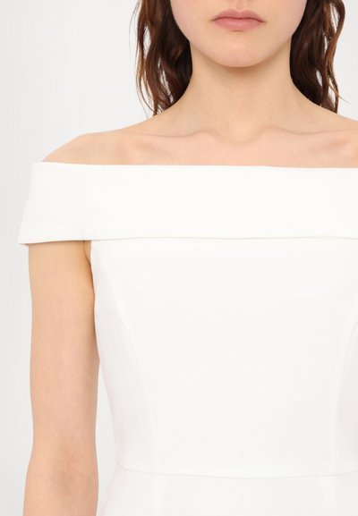 Vestido branco off-shoulder com um corpete estruturado, textura de tecido suave e linhas limpas. Design minimalista sem fechos visíveis.