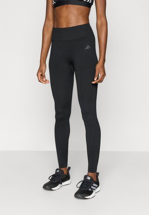 Μαύρο αθλητικό κολάν με ψηλή μέση, από λεία, ελαστική ύφανση· διαθέτει διακριτική λεπτομέρεια λογότυπου στο πάνω μέρος του μηρού.