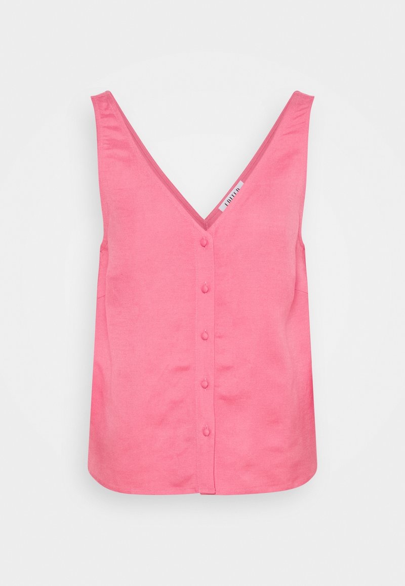 Blouse rose sans manches avec col en V et boutons recouverts de tissu sur le devant sur fond blanc.