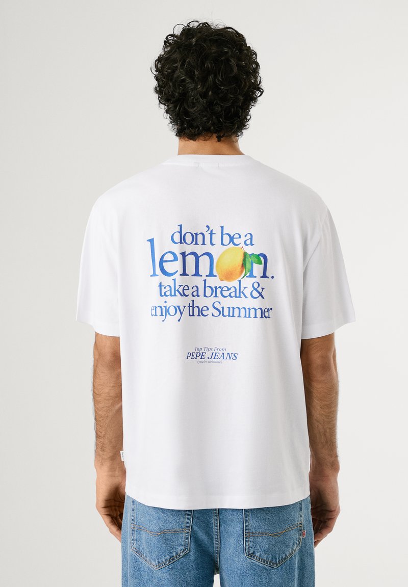 White cotton t-shirt featuring colorful text design on the back: "don’t be a lemon. take a break & enjoy the Summer." Casual fit.