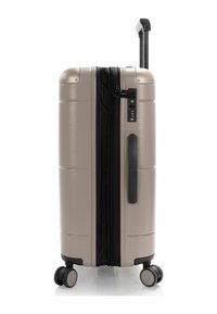 Valigia rigida di colore beige metallico con finitura testurizzata. Dotata di manico telescopico, lucchetto a combinazione e quattro ruote girevoli doppi.