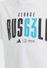Bílý bavlněný tričko s černým a tyrkysovým potiskem včetně nápisu "GEORGE RUS 63", s logy Adidas a Mercedes níže.