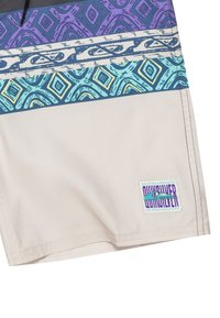 Costume da bagno con base beige e vita testurizzata in un motivo geometrico viola, blu e verde scoperto. Logo Quiksilver sul lato.