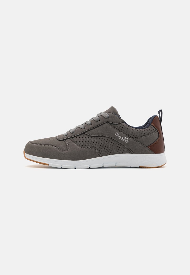 Gray sneaker with perforated mesh and suede. Features brown accents and a white sole. Lace-up design with a pull tab at the heel.