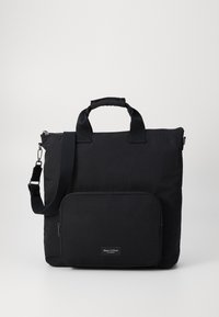 Sac fourre-tout en nylon noir comprenant deux poignées courtes, une bandoulière amovible et une poche zippée à l'avant. Comprend une étiquette de logo de marque.