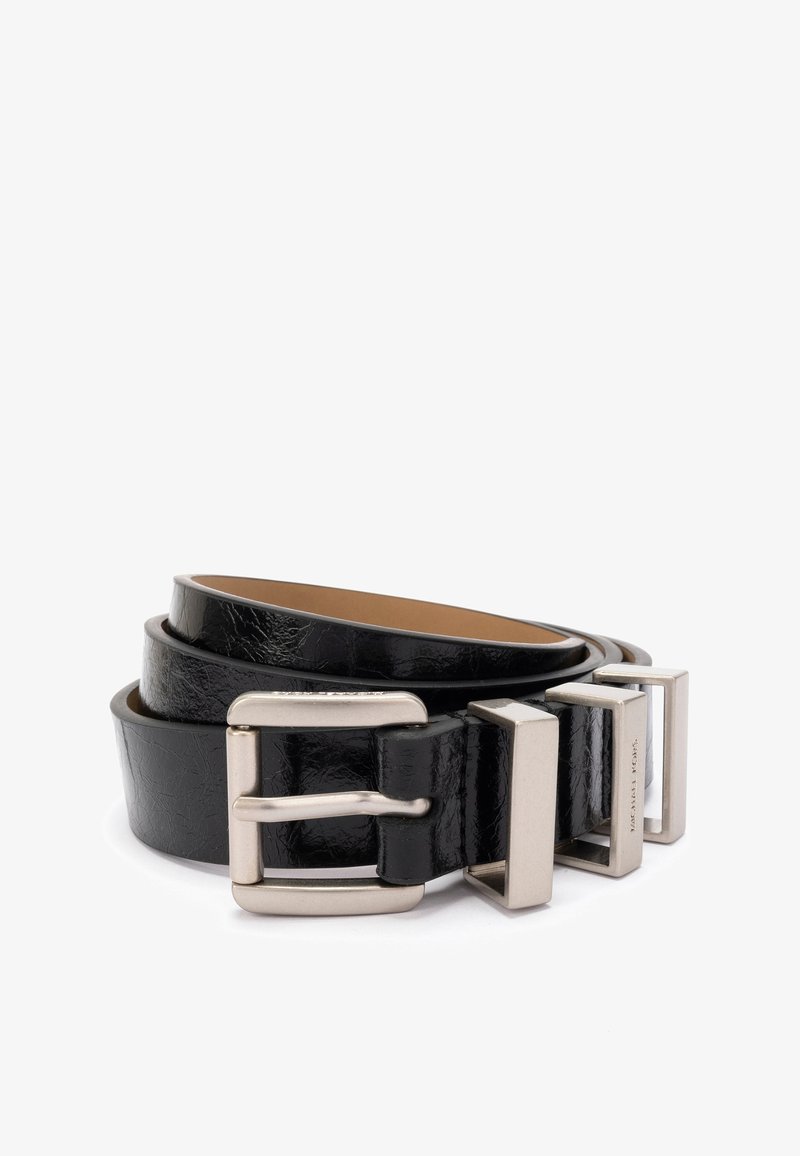 Ceinture en cuir noir avec une finition texturée, dotée d'une boucle en métal argenté. La ceinture est enroulée, montrant son intérieur lisse.