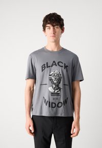 Grå bomulls t-shirt med en grafisk tryck av en hand som håller en byst med texten "BLACK WIDOW" och "EST 1993" under. Kort ärm, rund hals.